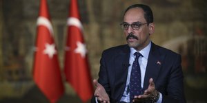 Ιμπραΐμ Καλίν μπροστά από σημαίες