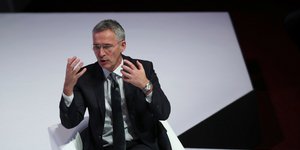 O Γιενς Στόλτενμπεργκ δίνει ομιλία καθήμενος σε λευκή καρέκλα