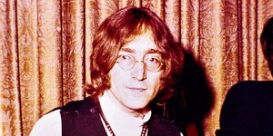 Ο Τζον Λένον με γυαλιά και μαύρο γιλέκο