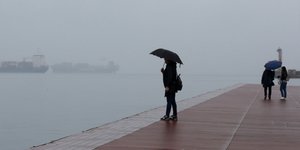 Ανθρωπος κάθεται με κακοκαιρία μπροστά σε προβλήτα