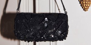 μαύρη τσάντα με παγιέτες περασμένη σε κηροπήγιο