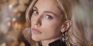 H Mαριάννα Γουλανδρή με μαύρο φόρεμα και σκουλαρίκια ποζάρει στον φακό