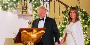 η Μελάνια Τραμπ με λευκό φόρεμα πιασμένη χέρι χέρι με τον Ντόναλντ Τραμπ