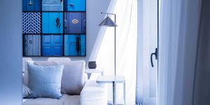 Καθιστικό διαμερίσματος με φωτιστικό, μπλε πίνακα, μαξιλάρια, καναπέ