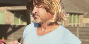 Άνδρας με περούκα και πολύ στενό μπλουζάκι
