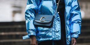 γυναίκα με puffer jacket και τσάντα στην εβδομάδα μόδας