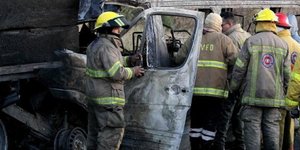 Πυροσβέστες δίπλα σε καμένο όχημα