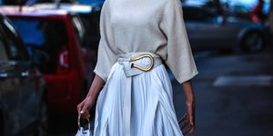 γυναίκα με φούστα και ζώνη περπατά στο δρόμο