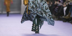 Γυναίκα περπατάει σε πασαρέλα με πέδιλα