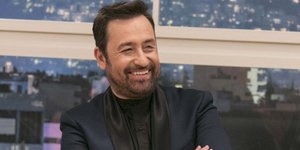 Ο Θέμης Γεωργαντάς με τα χέρια σταυρωμένα και μαύρο κοστούμι