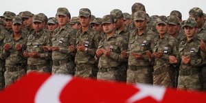 Τούρκοι στρατιώτες δίπλα σε φέρετρο με σημαία