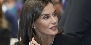 Η βασίλισσα Λετίθια κάθεται με φόρεμα και κάπα και κοιτά