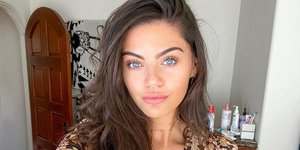 Μια κοπέλα με γαλάζια μάτια ποζάρει στο φακό 