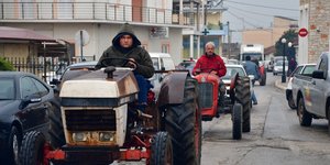 Αγρότες πάνω σε τρακτέρ σε επαρχιακό δρόμο