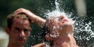 Άνδρας κάτω από τρεχούμενο νερό σε ημέρα ιδιαίτερα υψηλής ζέστης