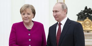 Η Γερμανίδα καγκελάριος Άνγκελα Μέρκελ με φούξια ταγέρ και ο Ρώσος πρόεδρος Βλάντιμιρ Πούτιν με σακάκι και μπορντό γραβάτα