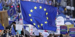 Διαδηλωτές κρατούν μια μεγάλη σημαία της Ευρωπαϊκής Ένωσης