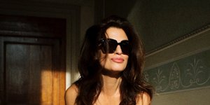 Η Δωροθέα Μερκούρη με σεντόνι τυλιγμένο στο σώμα της και γυαλιά ηλίου