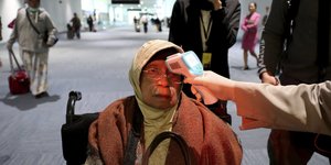 Έλεγχος θερμοκρασίας για την πρόληψη κοροναϊού σε γυναίκα επιβάτη στο αεροδρόμιο