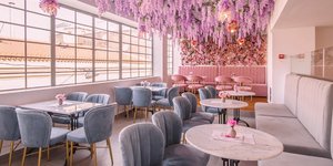 Λουλούδια στο ταβάνι, καρέκλες και μαρμάρινα τραπέζια στο εσωτερικό του Ellyz Athens