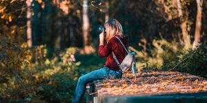 Μια γυναίκα φωτογραφίζει το δάσος καθισμένη