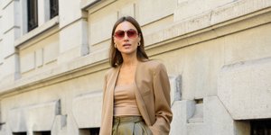 γυναίκα με μπεζ σακάκι παντελόνι και γυαλιά στην εβδομάδα μόδας