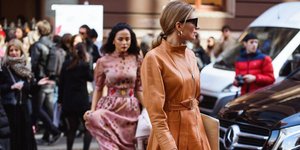 Γυναίκα με καφέ δερμάτινο φόρεμα στο δρόμο 