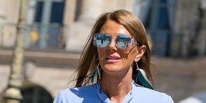 Γυναίκα με γαλάζιο πουκάμισο και καφέ παντελόνι στο δρόμο 