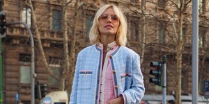 Μια γυναίκα με γαλάζιο σακάκι και γυαλιά στο δρόμο 