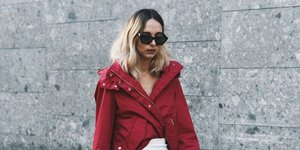 γυναίκα περπατά στην εβδομάδα μόδας με τζάκετ και φούστα