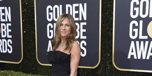 Η Τζένιφερ Άνιστον με μαύρη τουαλέτα χαμογελά