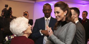 Η Κέιτ Μίντλετον χαμογελά και μιλά με γυναίκα