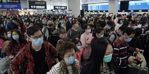 Πολίτες στην Κίνα με μάσκες για να αποφύγουν να έρθουν σε επαφή με τον κοροναϊό