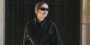 γυναίκα με δερμάτινο πουκάμισο και λευκό παντελόνι στην εβδομάδα μόδας