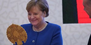 Η Μέρκελ κοιτά καθρέπτη και χαμογελά