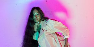 Η Ναόμι Κάμπελ με μακριά μαλλιά και πανωφόρι