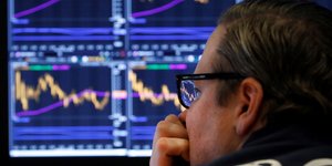 Ανδρας κοιτάζει τις οθόνες στο χρηματιστήριο