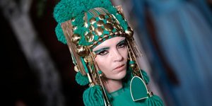 Μοντέλο σε πασαρέλα με πράσινο καπέλο