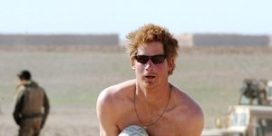 Ο πρίγκιπας Χάρι χωρίς μπλούζα με στρατιωτική στολή κρατά μπάλα