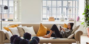 Σαλόνι σχεδιάστριας με καναπέ, τραπεζάκι, παράθυρο, φωτιστικό, φυτά 