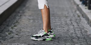 γυναίκα με sneakers και λευκά ρούχα στην εβδομάδα μόδας