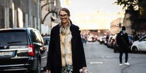 Γυναίκα με κομψά ρούχα και σκυλί περπατά