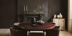 Τραπεζαρία διαμερίσματος με μαύρο τοίχο, διακοσμητικά αξεσουάρ, καρέκλες, τζάκι