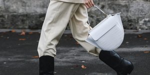 γυναίκα περπατά με μπότες και τσάντα στο δρόμο