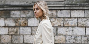 γυναίκα περπατά στην εβδομάδα μόδας με κοστούμι και τσάντα