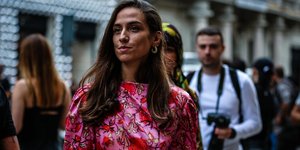 γυναίκα με φόρεμα και σκουλαρίκια περπατά στην εβδομάδα μόδας