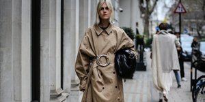 γυναίκα με καμπαρντίνα και τσάντα στην εβδομάδα μόδας