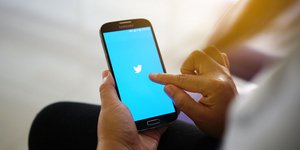 Χρήστης μπαίνει στο Twitter από το κινητό του τηλέφωνο
