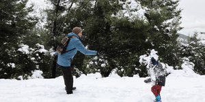Άνδρας και παιδί παίζουν στα χιόνια στην Πάρνηθα