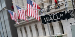 Πινακίδα της Wall Street και σημαίες έξω από το χρηματιστήριο